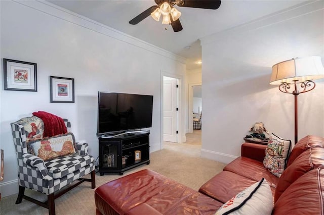 living area with carpet floors, ceiling fan, crown molding, and baseboards
