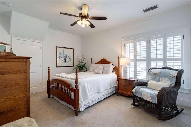 bedroom featuring light colored carpet, ornamental molding, and a ceiling fan