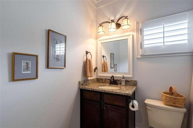 half bath featuring vanity and toilet