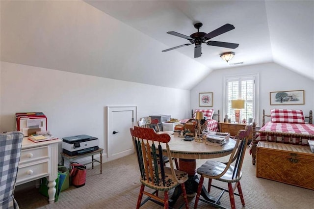 carpeted dining space featuring vaulted ceiling and a ceiling fan