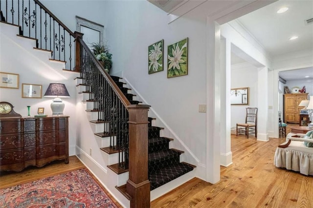 stairs featuring wood finished floors, baseboards, and recessed lighting