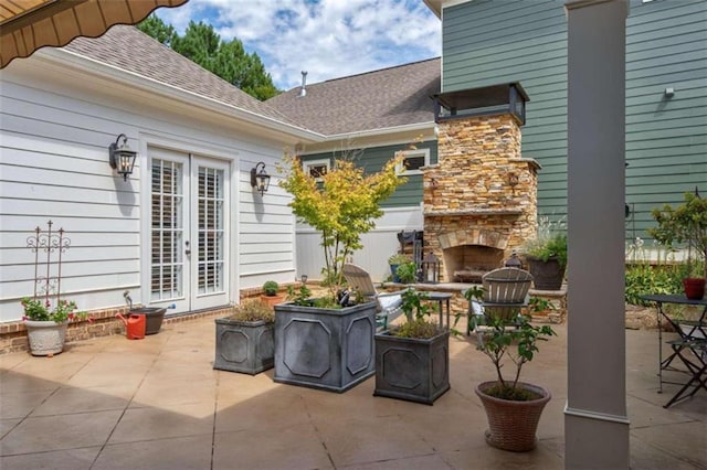 view of patio / terrace with an outdoor stone fireplace and french doors