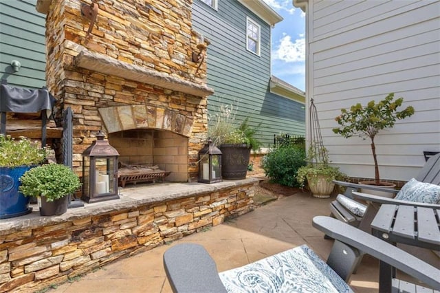 view of patio / terrace featuring an outdoor stone fireplace