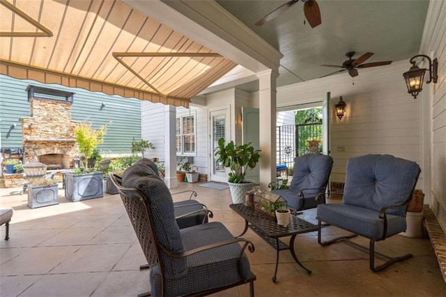 view of patio / terrace with an outdoor living space with a fireplace and a ceiling fan