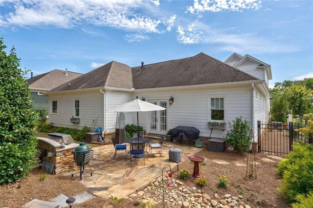 rear view of property with a patio area, french doors, fence, and roof with shingles