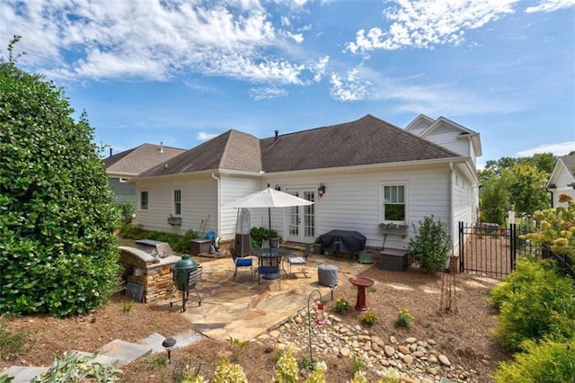 rear view of property with french doors, a patio area, fence, and roof with shingles