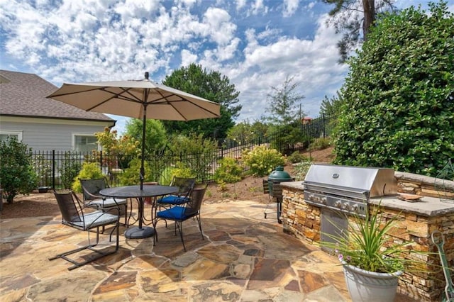 view of patio featuring a grill, fence, area for grilling, and outdoor dining space