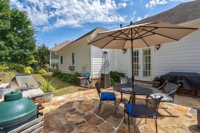 view of patio featuring french doors, outdoor dining space, and area for grilling
