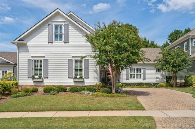 view of front of home with a front lawn and decorative driveway