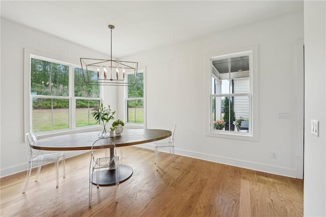 dining area featuring baseboards, wood finished floors, and a chandelier