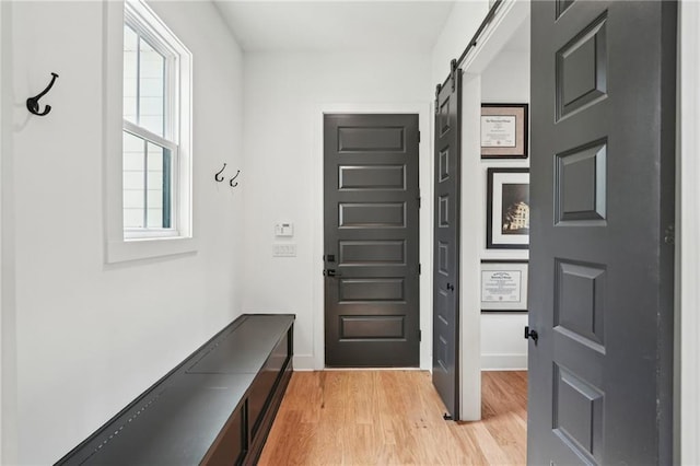 mudroom featuring light wood-type flooring and a barn door