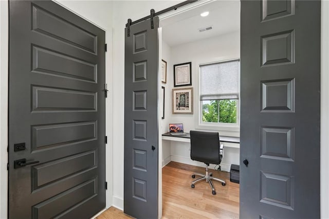 office space with baseboards, visible vents, and light wood-style flooring