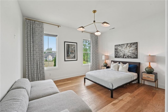 bedroom featuring baseboards, visible vents, and wood finished floors