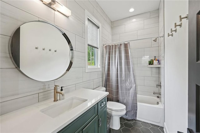 bathroom with shower / bath combo with shower curtain, tile patterned flooring, vanity, toilet, and tile walls