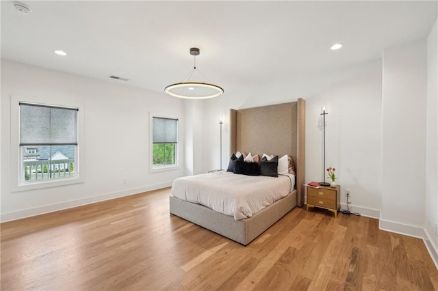 bedroom with visible vents, recessed lighting, light wood finished floors, and multiple windows