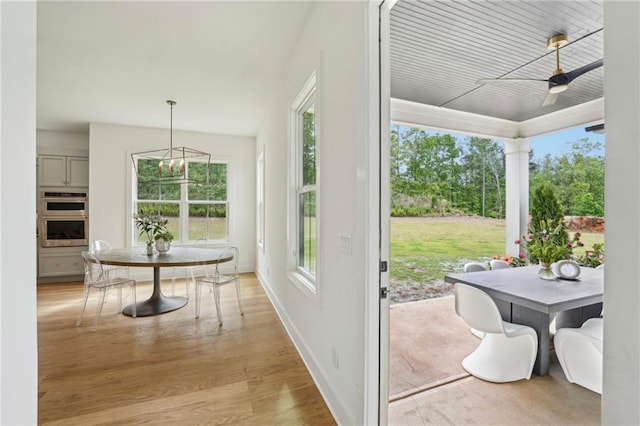 doorway with a ceiling fan, baseboards, a wealth of natural light, and light wood-type flooring