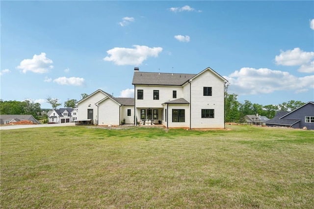 rear view of property featuring a chimney and a yard