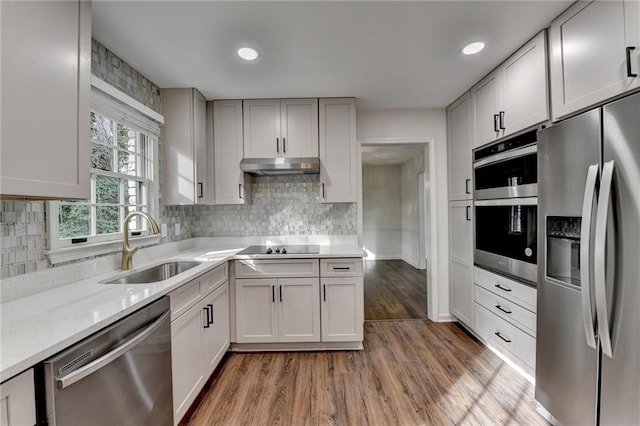 kitchen with sink, white cabinets, appliances with stainless steel finishes, and light hardwood / wood-style flooring