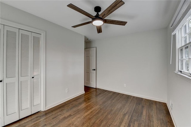 unfurnished bedroom featuring ceiling fan, a closet, and dark hardwood / wood-style flooring