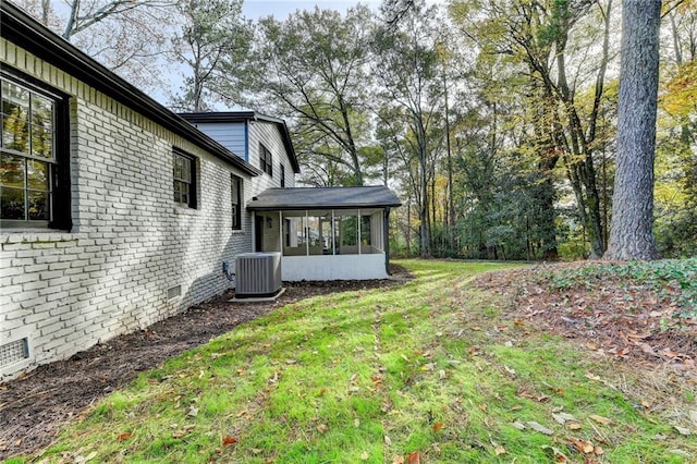 view of yard with a sunroom and central AC