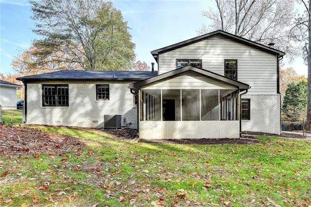 back of property featuring a sunroom, a yard, and central AC