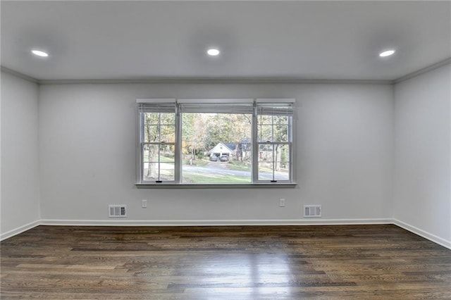 spare room featuring dark hardwood / wood-style floors and ornamental molding