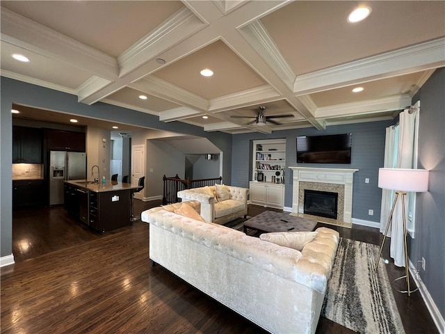 living room with beamed ceiling, coffered ceiling, dark hardwood / wood-style flooring, and sink