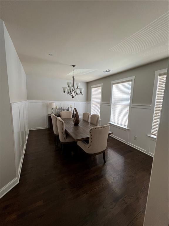 dining room with dark hardwood / wood-style floors and a chandelier