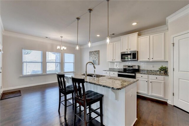 kitchen with white cabinetry, tasteful backsplash, light stone counters, ornamental molding, and appliances with stainless steel finishes