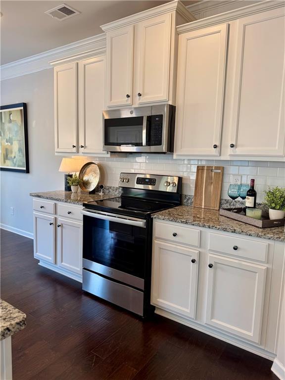 kitchen featuring light stone counters, appliances with stainless steel finishes, sink, and white cabinets