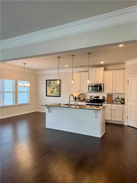 empty room featuring ceiling fan, ornamental molding, dark hardwood / wood-style floors, and a healthy amount of sunlight