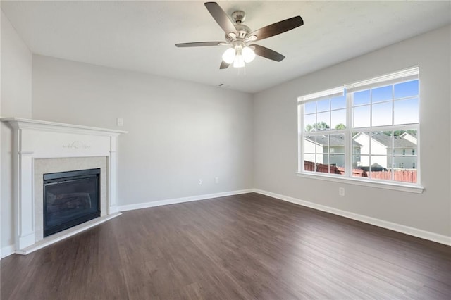 139 Palmetto St, Locust Grove, GA 30248 - unfurnished living room with dark wood-type flooring, baseboards, a ceiling fan, and a glass covered fireplace