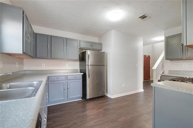 139 Palmetto St, Locust Grove, GA 30248 - kitchen with freestanding refrigerator, a sink, dark wood finished floors, gray cabinets, and light countertops