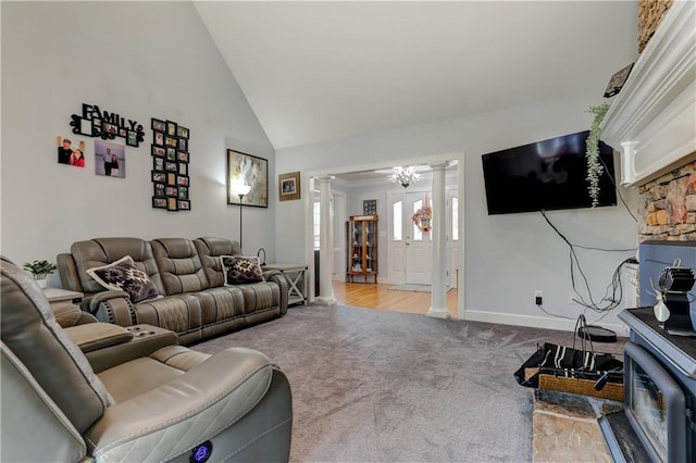 living area with ornate columns, carpet, baseboards, and high vaulted ceiling