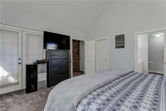 bedroom with dark colored carpet, ensuite bathroom, and high vaulted ceiling