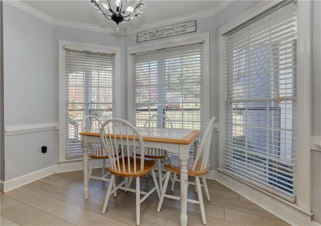 dining area with a chandelier, crown molding, baseboards, and wood finished floors