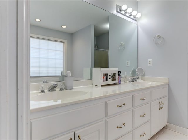 bathroom featuring double vanity, tile patterned flooring, an enclosed shower, and baseboards
