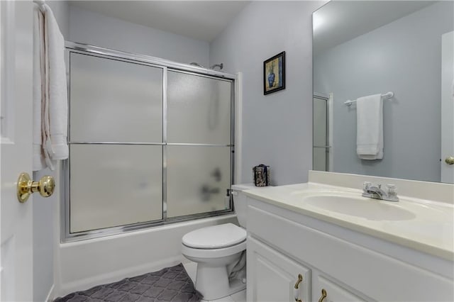 bathroom with toilet, bath / shower combo with glass door, vanity, and tile patterned floors