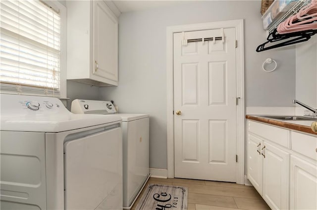 laundry room with washer and dryer, cabinet space, and light wood-type flooring