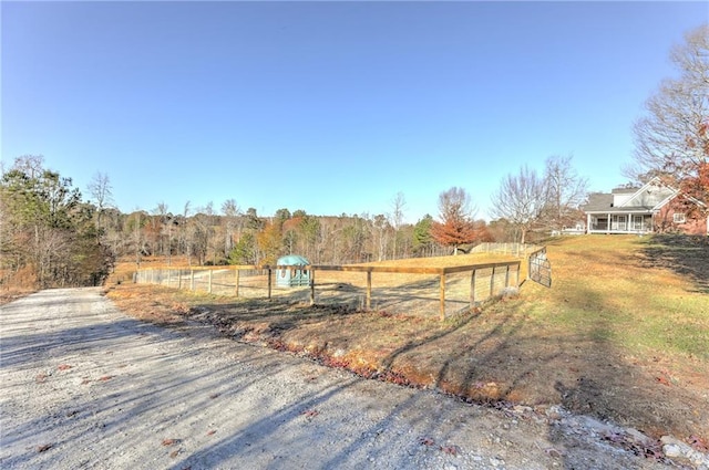 view of yard with fence and a view of rural / pastoral area
