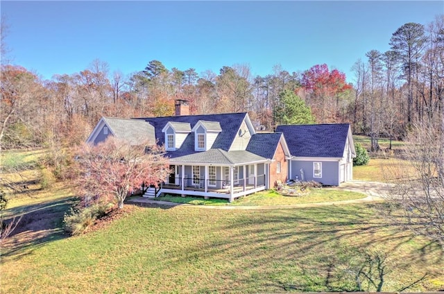 rear view of house with a lawn, a chimney, and concrete driveway