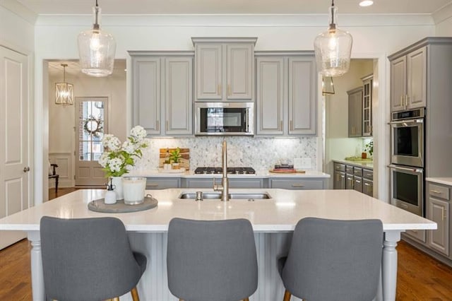 12603 Itaska Walk, Milton, GA 30004 - kitchen featuring appliances with stainless steel finishes, gray cabinets, light countertops, a kitchen breakfast bar, and crown molding
