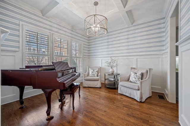 12603 Itaska Walk, Milton, GA 30004 - living area featuring wallpapered walls, coffered ceiling, a chandelier, a decorative wall, and wood finished floors