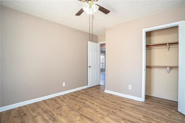 unfurnished bedroom with light hardwood / wood-style flooring, ceiling fan, a closet, and a textured ceiling