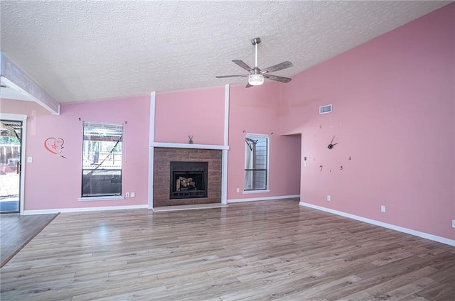 unfurnished living room featuring a textured ceiling, lofted ceiling, ceiling fan, and wood-type flooring