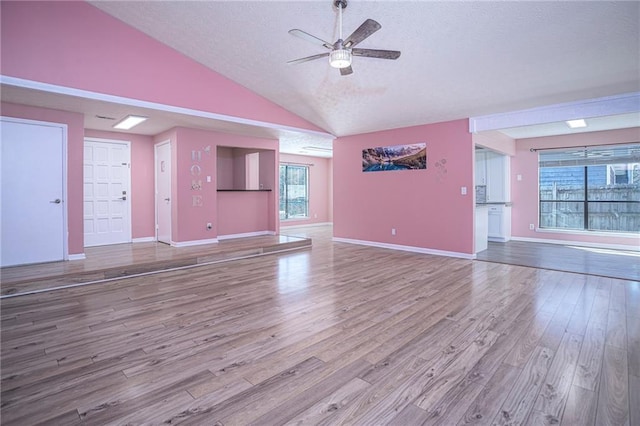 unfurnished living room featuring vaulted ceiling, hardwood / wood-style floors, and ceiling fan