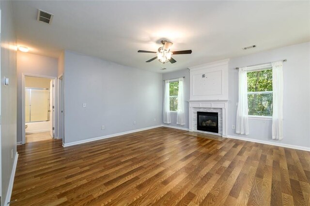 unfurnished living room featuring ceiling fan and dark wood-type flooring