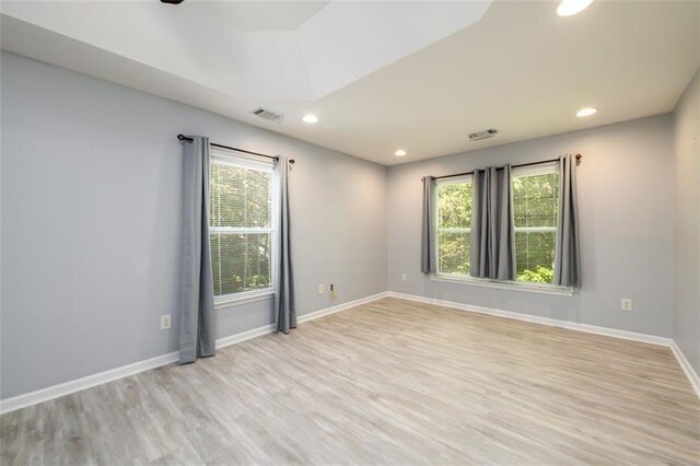 empty room with ceiling fan and light hardwood / wood-style flooring