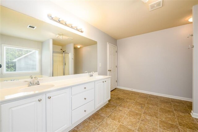 bathroom with a shower with shower door and vanity