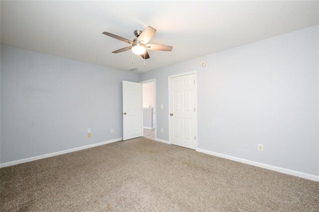 carpeted spare room with ceiling fan